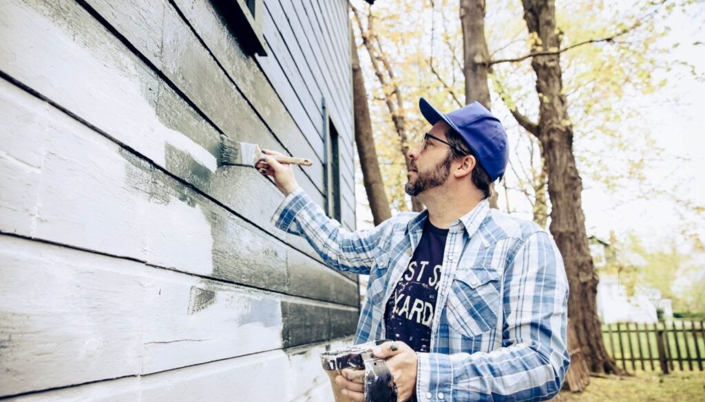 Side view of man painting exterior of home-min(1)